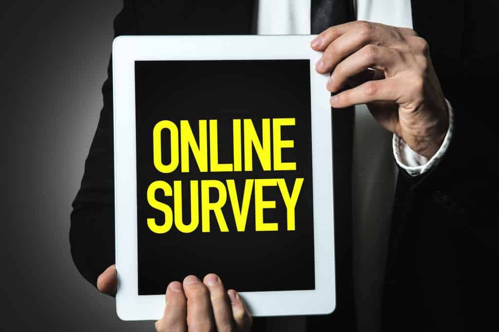 man holding an online survey on a tablet in his hands