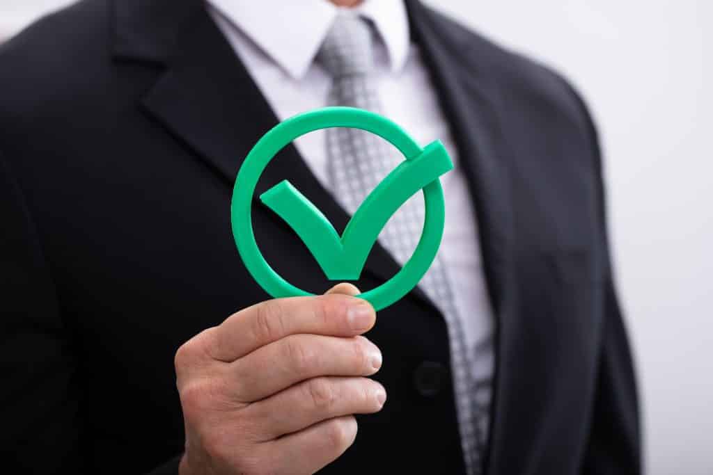 man holding an online survey panel checkmark