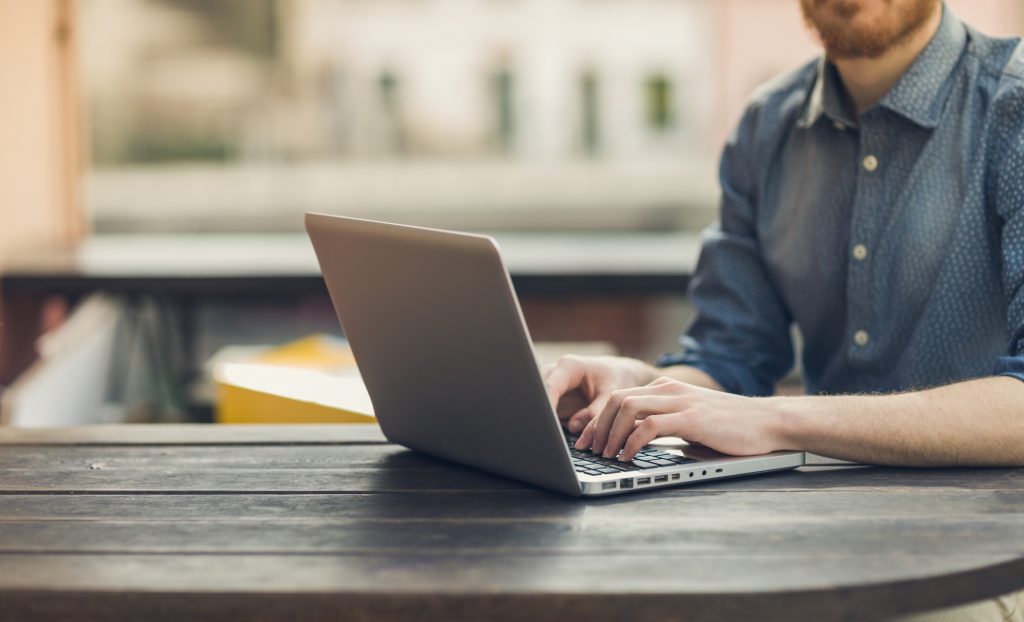 man doing online surveys on his laptop