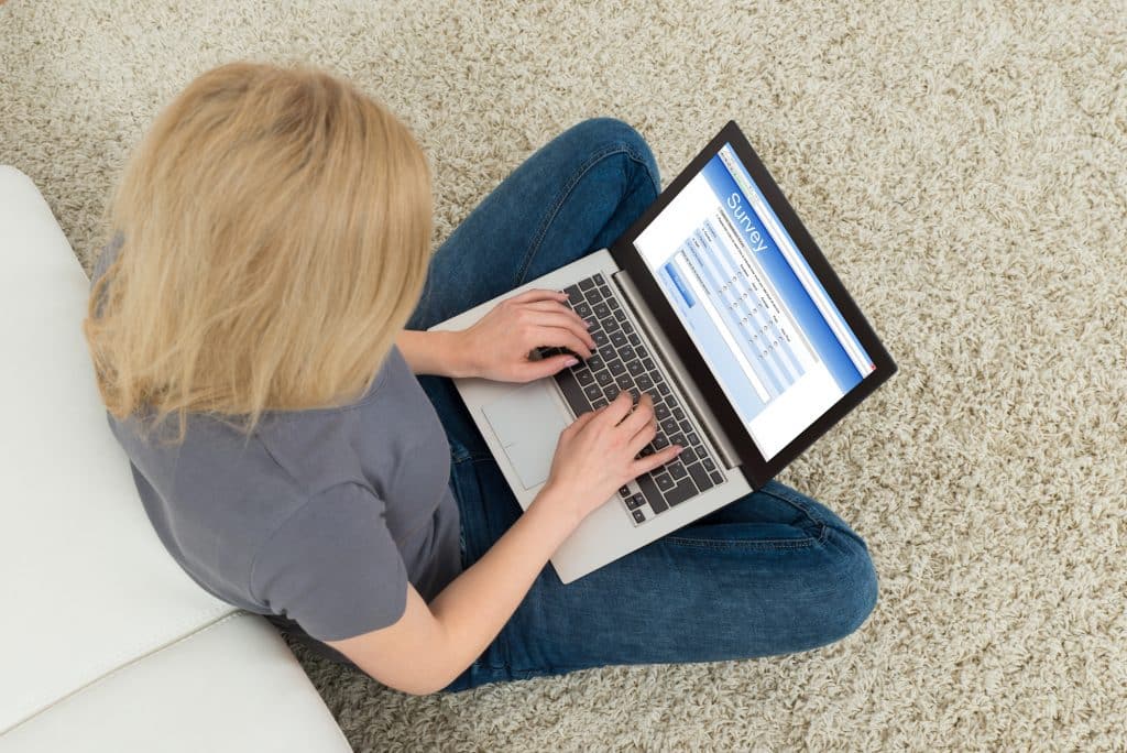 girl doing online surveys on her laptop