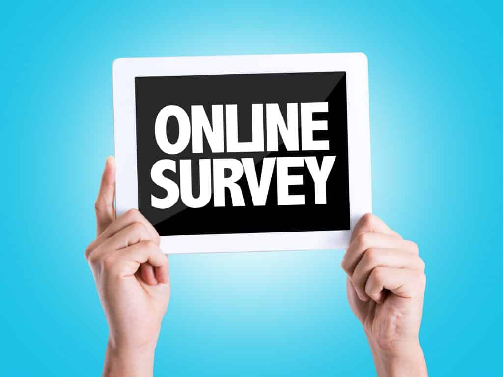 person holding an online survey sign